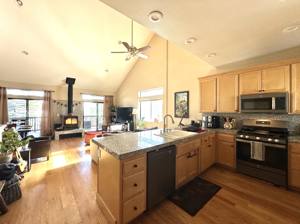 Open kitchen and living area with a fire burning in the wood stove